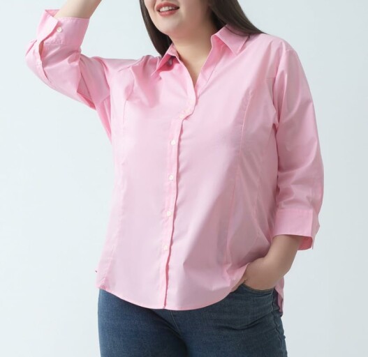 Woman in a stylish button-down shirt with a confident pose.