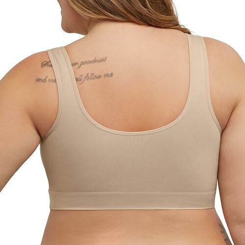 Back view of a beige plus-size bra worn by a person.