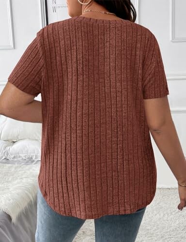 Person wearing a brown ribbed short-sleeve shirt, viewed from the back.