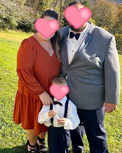 Family in formal attire standing on grass.