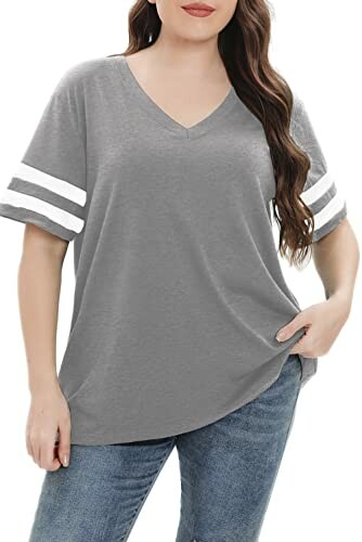 Woman wearing a grey V-neck T-shirt with white stripes on sleeves.