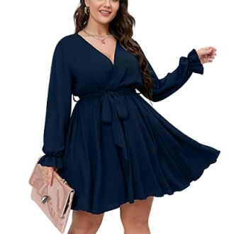 Woman in navy long sleeve wrap dress holding a clutch