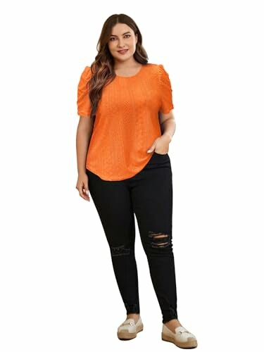 Woman wearing orange top and black jeans