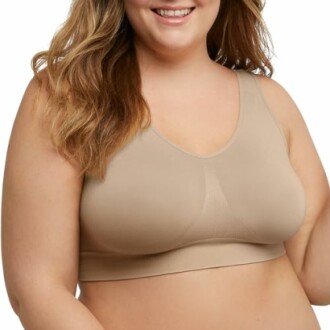 Woman wearing a beige bra, smiling.