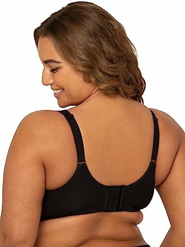 Woman wearing a black bra, viewed from the back.