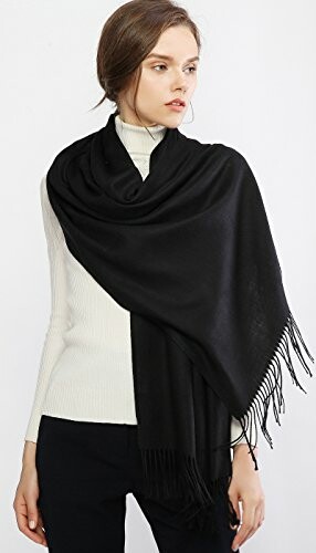 Woman wearing a black shawl over a white sweater.