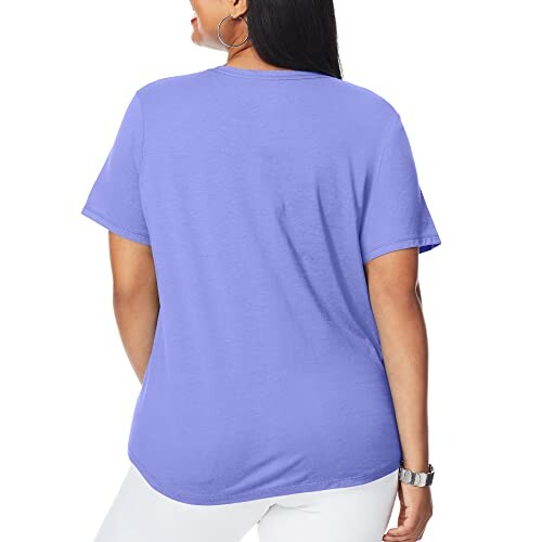 Back view of a woman wearing a purple T-shirt and white pants.