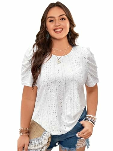 Woman in white eyelet top with blue jeans.